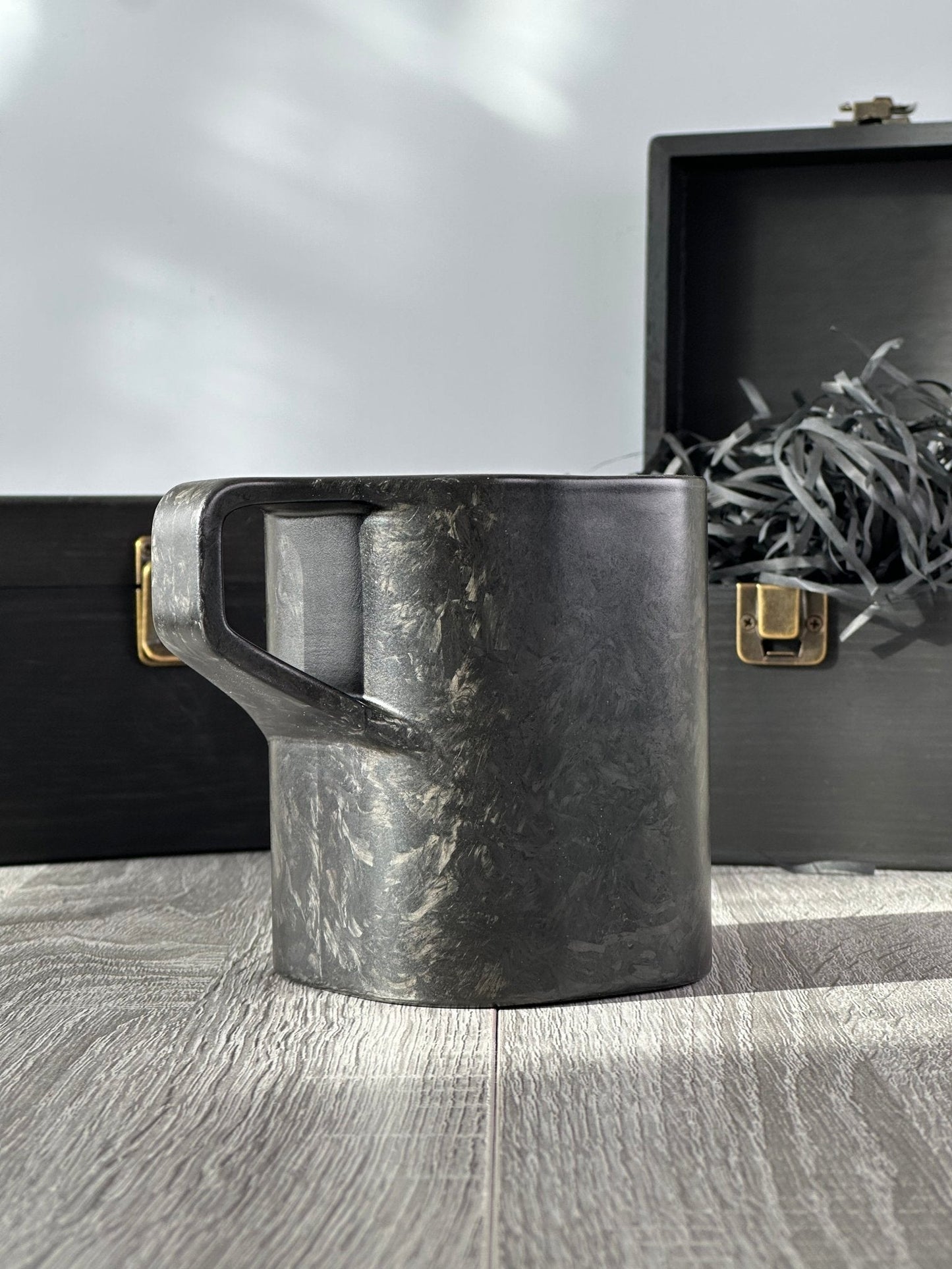 Front-angled view of carbon fibre mug – Quotidiano Edition 2 – with premium wooden gift packaging